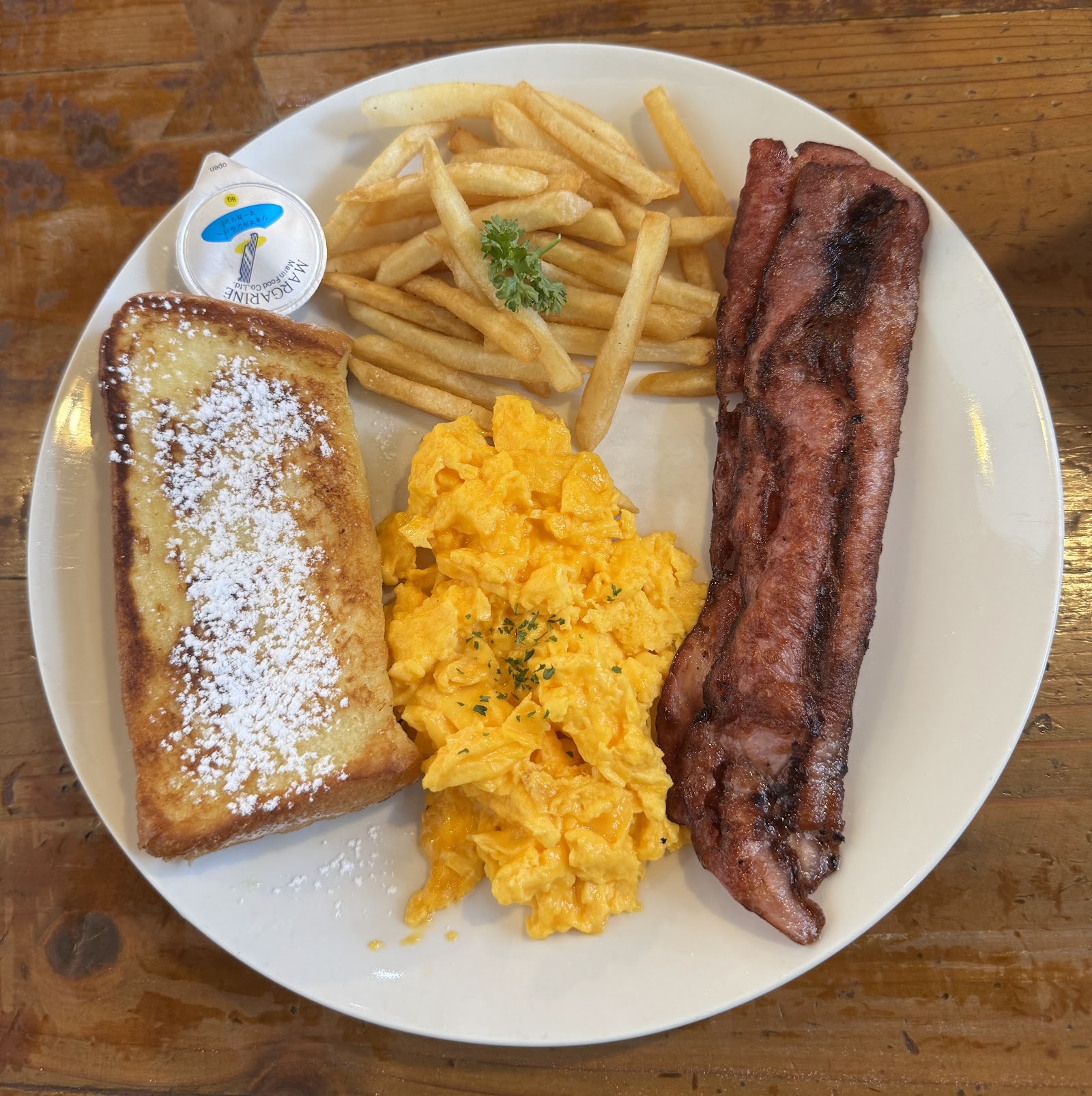 French toast breakfast plate with eggs, bacon, and potatoes