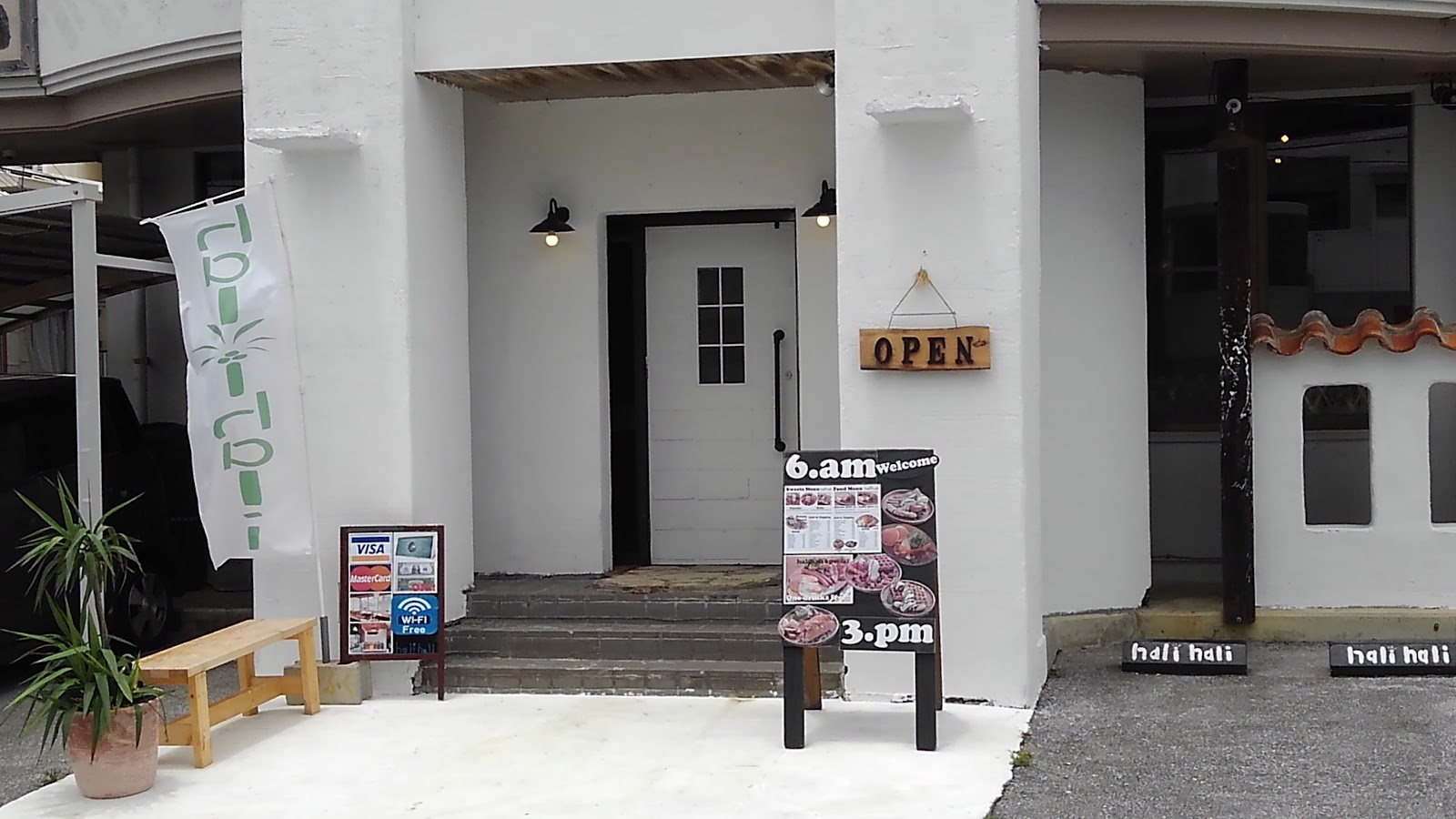 Hali Hali white plaster storefront and wood door in Chatan